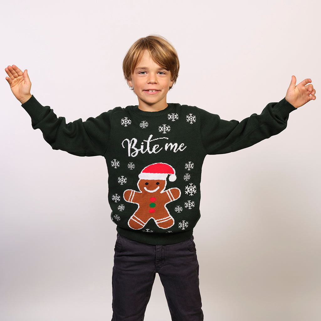 En dreng med en grøn julesweater med en kagemand og citater